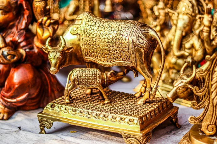 a gold cow statue sitting on top of a wooden platform